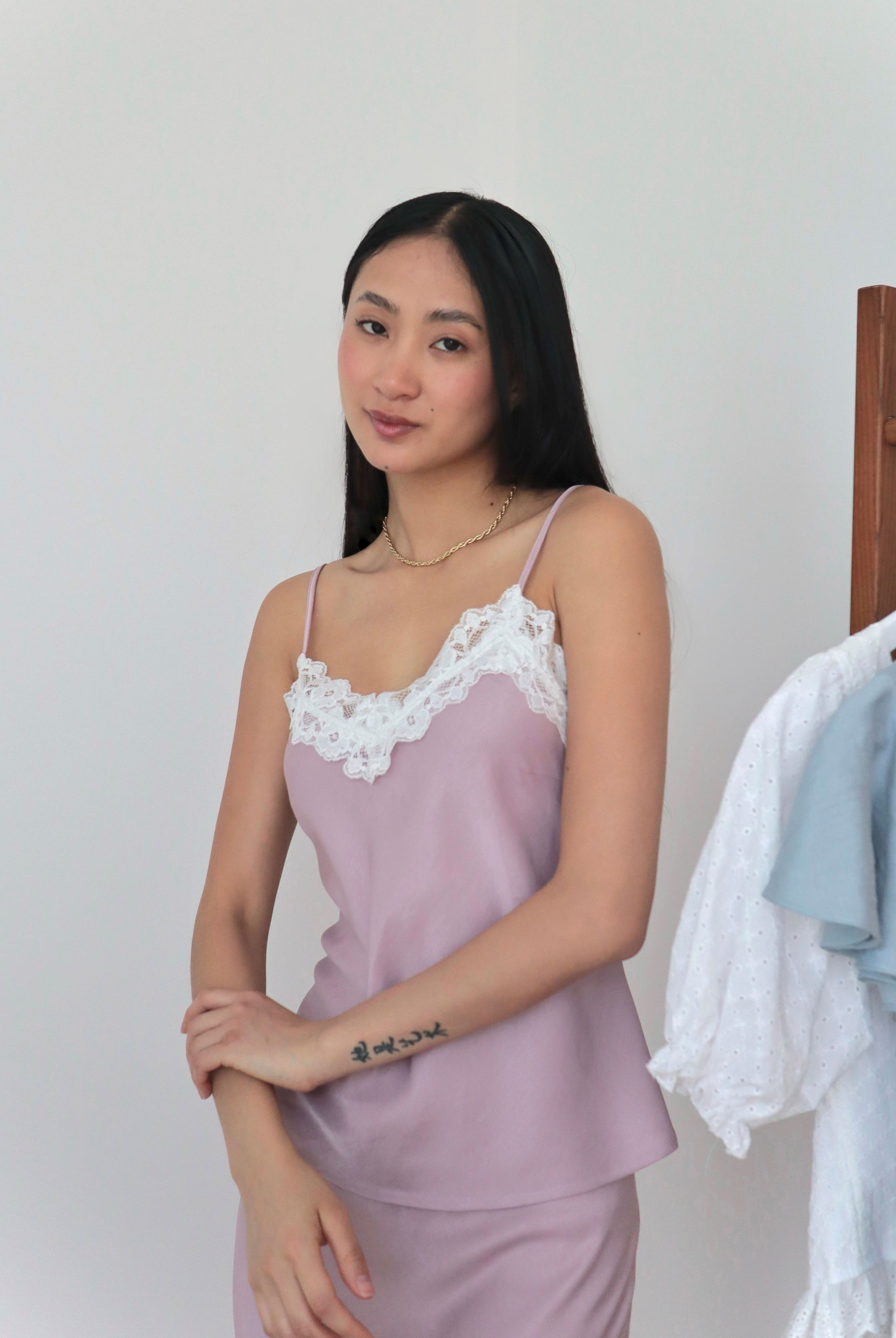 Mujer usando top midi lencero color rosa romántico en fondo blanco