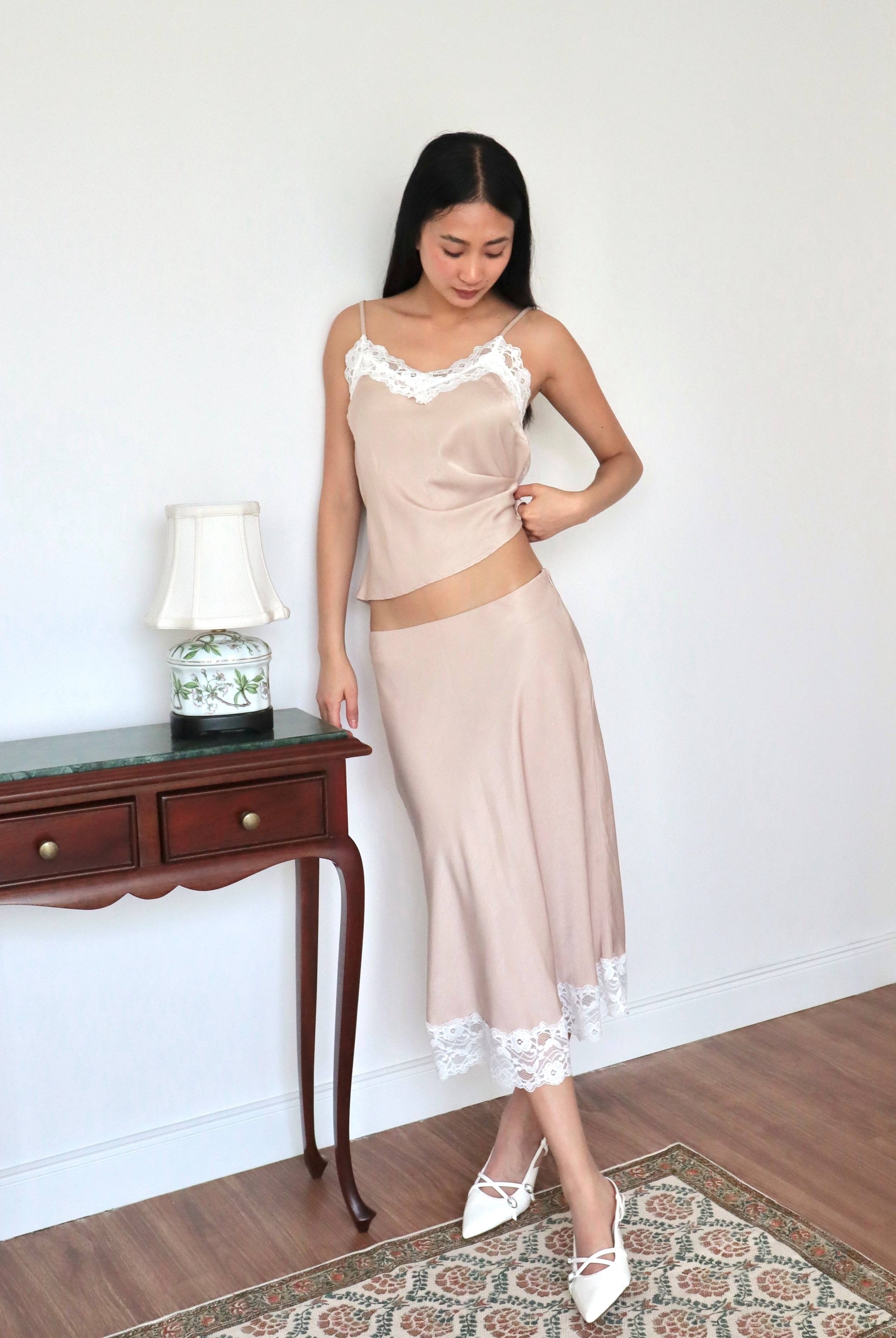 Mujer posando usando conjunto estilo lencero color champagne.