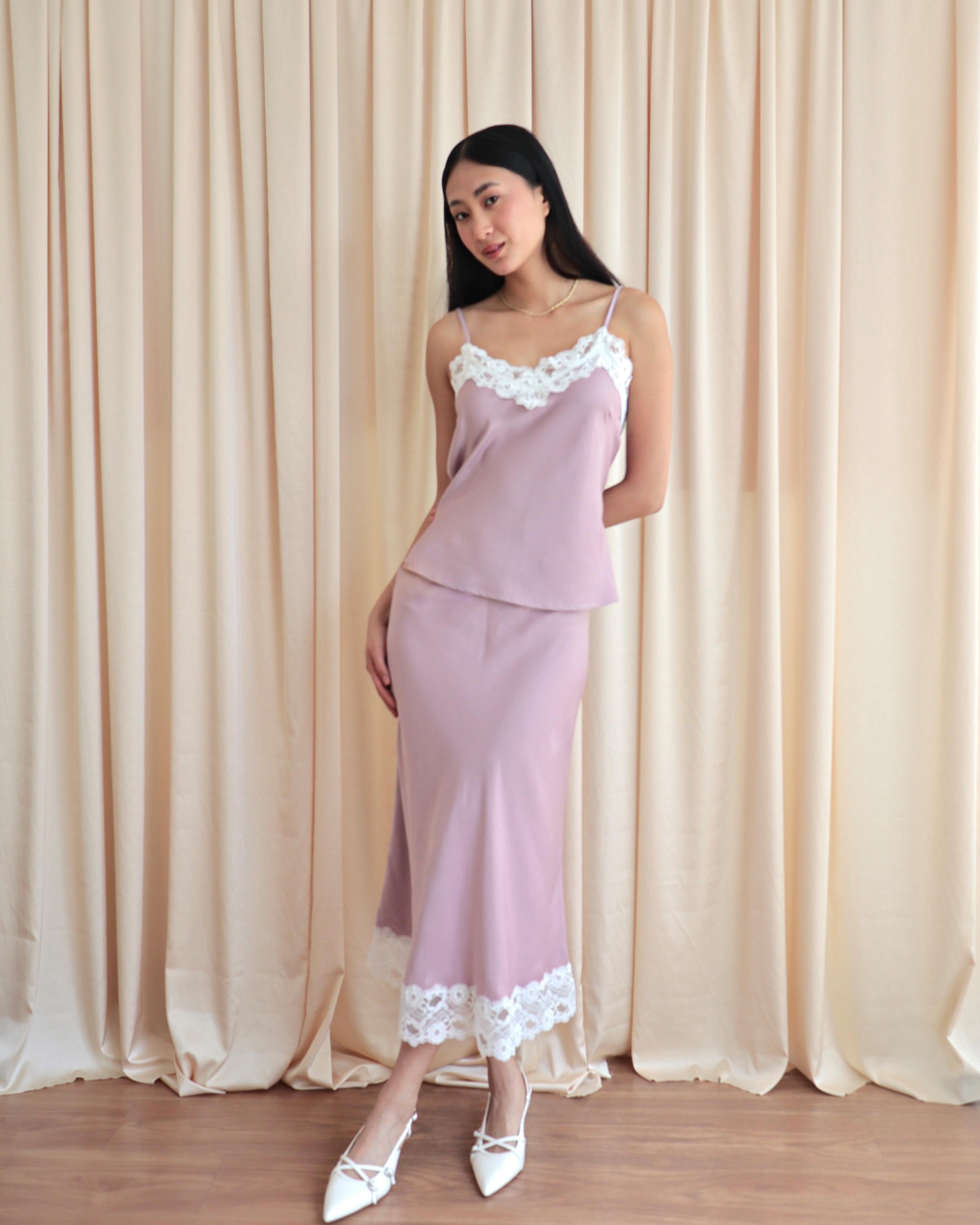 Mujer usando set de seda estilo lencero color rosa.
