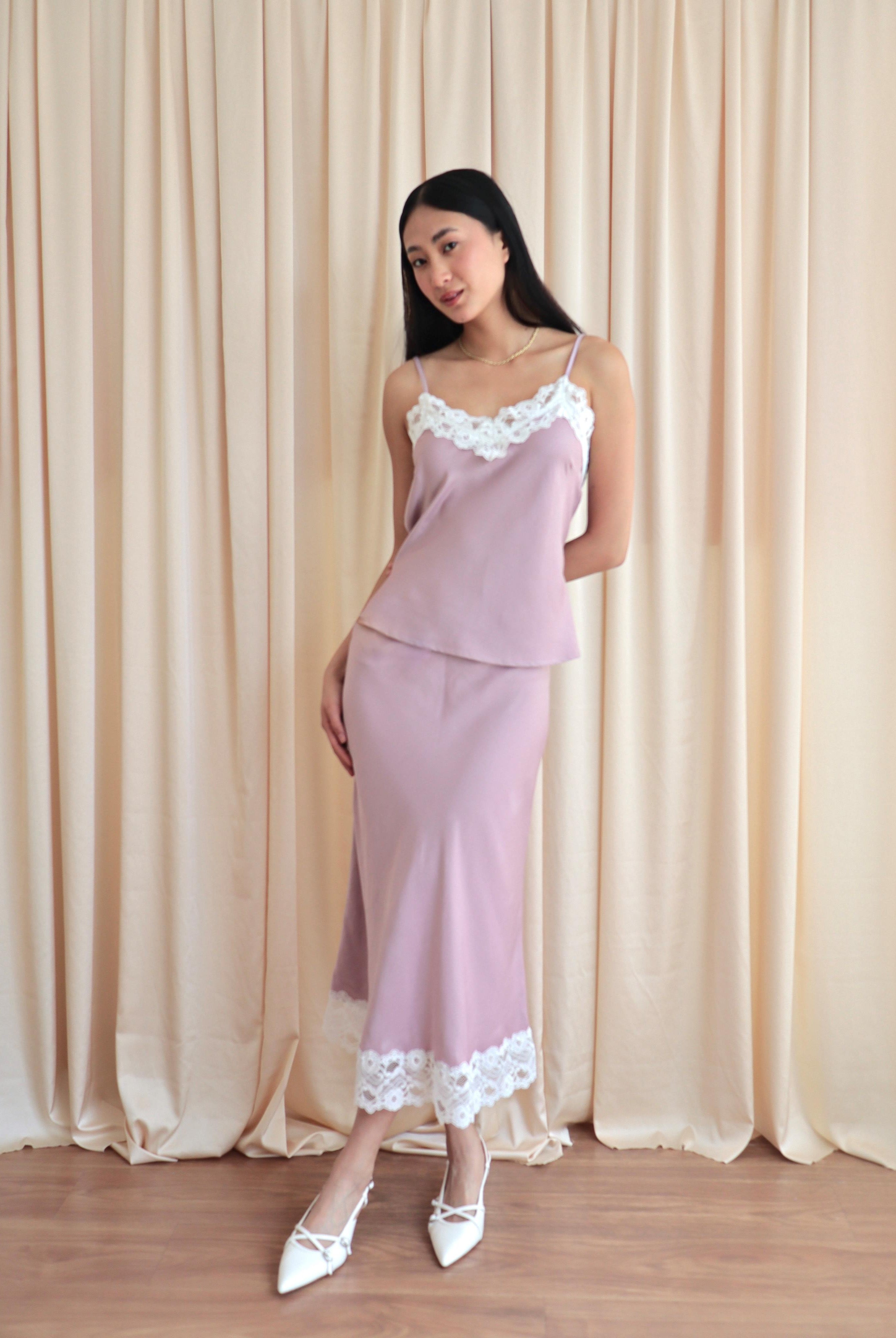 Mujer usando set de seda estilo lencero color rosa.