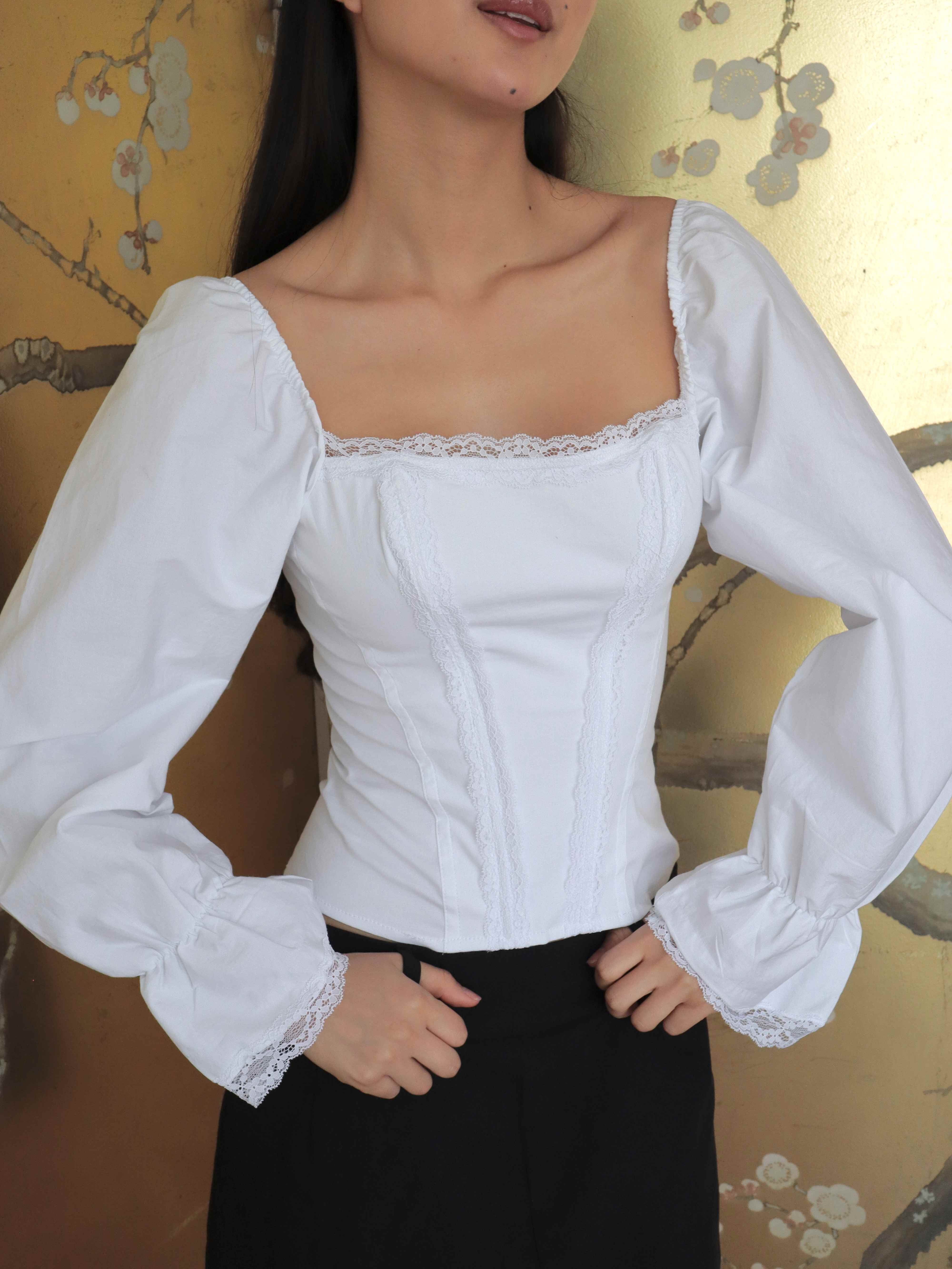 Mujer usando corset de algodón, mangas largas y blondas. Posando en fondo floral.